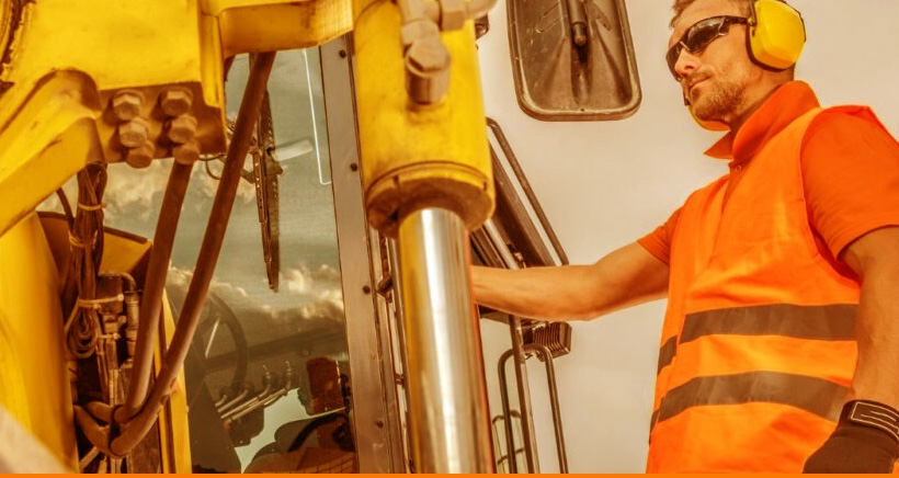 Homme dans excavatrice sur chantier de construction